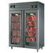 A stainless steel Maturmeat meat aging and curing cabinet with glass doors full of meat.