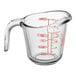 A clear glass Anchor Hocking measuring cup with a red handle and red measurement markings.