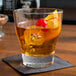 An Arcoroc stackable rocks glass with a drink, ice, and a cherry.