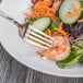 A Oneida Baguette stainless steel dessert fork in a bowl of vegetables.