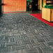 A gray Cactus Mat Tire-Tex carpet tile installed in a carpeted area.