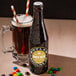 A bottle of Boylan Original Birch Beer next to a glass of dark soda.