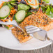 A plate of food with a fish knife and fork.