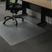 A black office chair on a ES Robbins clear vinyl chair mat in front of a desk.