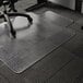 A black chair with an ES Robbins clear vinyl chair mat on low pile carpet.