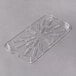 A Carlisle clear plastic food pan drain tray with small holes.