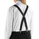 A person wearing Henry Segal black clip-end suspenders over a white shirt.