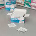 A box of Medi-First alcohol wipes on a table.