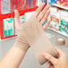 A person holding a roll of Medi-First self adhesive wrap.