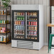 A white two-section glass door merchandiser refrigerator filled with various beverages and food items.