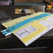 A desk with a blue C-Line plastic sorter holding yellow and blue papers.