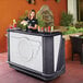 A woman standing behind a Cambro portable bar.