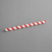 An EcoChoice red and white striped paper straw.