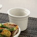 A Libbey white porcelain custard dish filled with food on a table.