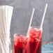 Two glasses of red drink with EcoChoice white paper straws.