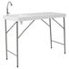 A white rectangular Flash Furniture folding table with a sink and faucet.