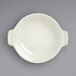 A white porcelain shirred egg dish with handles.