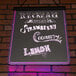 A white Aarco lighted write-on markerboard with neon writing that reads "ice cream, strawberry, coconut and lemon" on a brick wall.