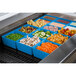 A blue Tablecraft bowl filled with food on a tray on a salad bar counter.