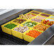 A yellow Tablecraft container filled with peas on a counter in a salad bar.