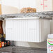 A Metro undershelf slide on a white Metro shelf with a container of food on it.