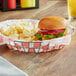 An American Metalcraft stainless steel wire basket with a burger and chips inside.