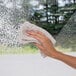 A hand using a towel to wipe a window with Weiman Foaming Glass Cleaner.