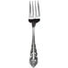 A close-up of a Walco stainless steel salad fork with a Baroque pattern on the handle.