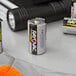 A Rayovac Ultra Pro Industrial D Alkaline battery in front of a box of Rayovac Ultra Pro Industrial D Alkaline batteries.