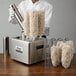 A man in a white coat and white gloves using a Noble Products Glass Genie electric glass polisher with a blow tube.