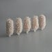 A group of five white Noble Products brush heads.