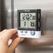 A hand using a Taylor digital kitchen timer.