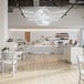 A room with a BFM Seating Relic Antique Wash rectangular table and white chairs.