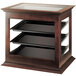 A Cal-Mil wooden three tier display case with rear door on a table in a bakery.