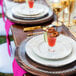 A table set with a 10 Strawberry Street silver beaded rim charger plate with a drink on it.