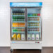 The left hinged door for an Avantco GDC-49 series refrigerator filled with drinks and juices.