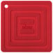 A red square silicone pot holder with text on it.