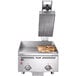 A Vulcan countertop electric griddle with a grooved steel plate and a closed lid cooking sandwiches.