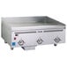 A stainless steel Vulcan commercial griddle on a counter with knobs.