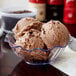 A clear tulip bowl filled with chocolate chip cookie ice cream.