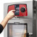 A person using a digital Vulcan MINI-JETR electric combi oven.