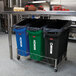 A blue Rubbermaid Slim Jim trash can under a kitchen counter.