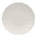 A white bone china bread and butter plate with a scalloped edge and embossed floral pattern.