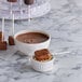 Paper lollipop sticks in a bowl of chocolate dip.