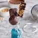 A counter with a variety of chocolate covered candies on Paper Lollipop sticks.