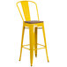 a yellow bar stool with a wooden seat