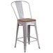 A Flash Furniture silver metal restaurant bar stool with a wooden seat and vertical slat back.