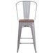 A Flash Furniture silver metal restaurant bar stool with a wooden seat and vertical slat back.