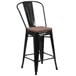 A black metal restaurant bar stool with a wood seat.