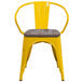 A yellow Flash Furniture metal restaurant chair with a wood seat and arms.
